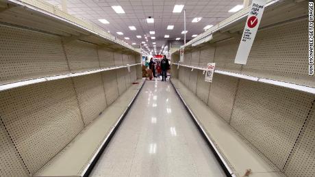Shelves normally stocked with hand wipes, hand sanitizer and toilet paper sit empty at a Target store in Arlington, Virginia, on March 13, 2020.