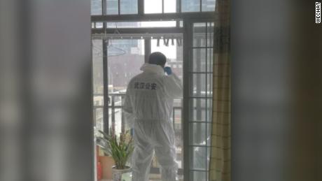  A photo on Wechat shows a local policeman in protective suit stationed on a balcony to discourage any potential yelling or jeers from residents.