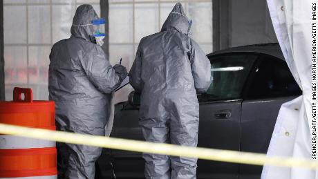 NEW ROCHELLE, NEW YORK - MARCH 13: Workers in protective gear operate a drive through COVID-19 mobile testing center on March 13, 2020 in New Rochelle, New York. The center serves all parts of Westchester County and will test up to 200 people today, growing to up to 500 people per day in the coming days. New Rochelle, a city just north of New York City, has become the state&#39;s largest source of coronavirus infections, prompting Governor Andrew Cuomo to implement the one mile radius &quot;containment area&quot; as the nation sees a daily increase in the number of virus cases.  (Photo by Spencer Platt/Getty Images)