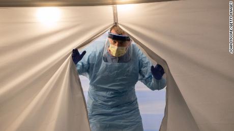 A nurse wearing protective clothing emerges from a tent at a coronavirus testing center at the University of Washington Medical Center on March 13 in Seattle.