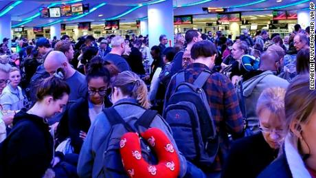 Travelers returning from Madrid wait in a coronavirus screening line at Chicago's O'Hare International Airport on Saturday.