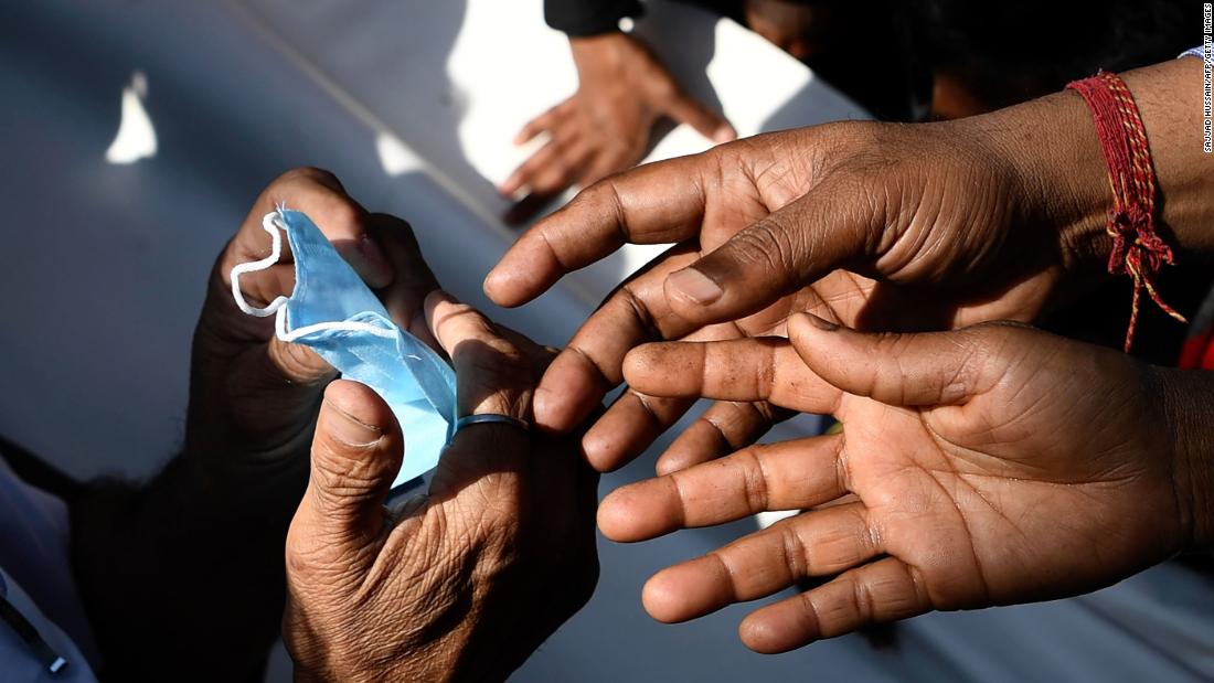 People gather to collect free face masks in New Delhi on March 17, 2020.