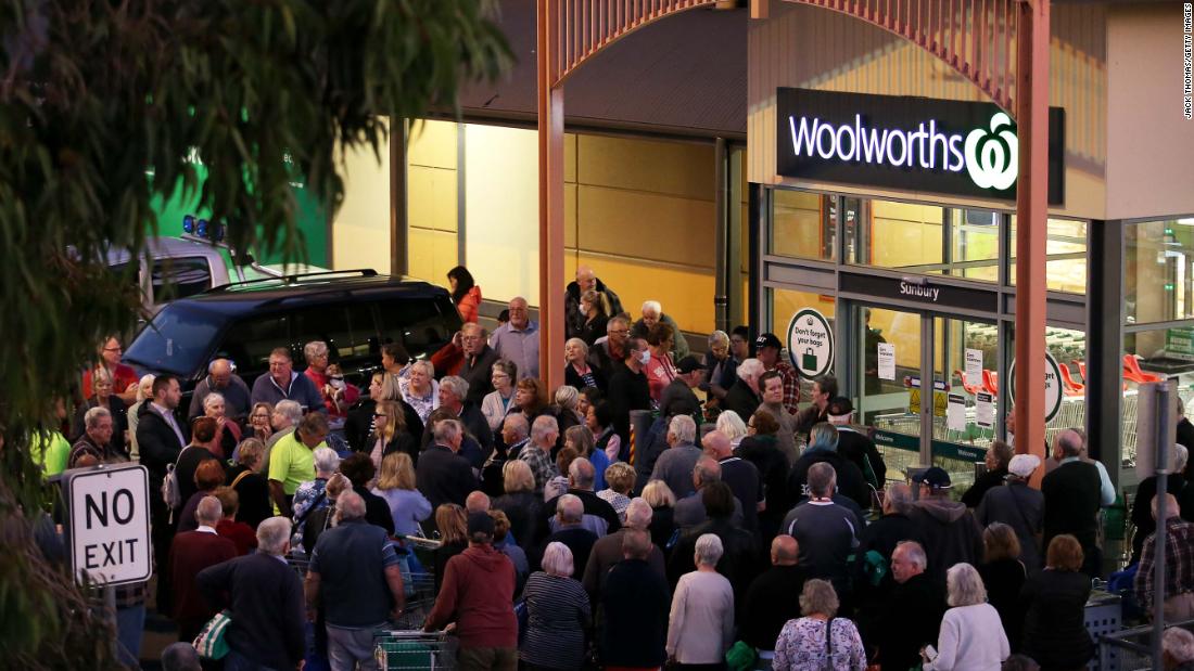 People wait outside a Woolworths store in Sunbury, Australia, on March 17, 2020. Australian supermarket chains announced special shopping hours for the elderly and people with disabilities so that they could shop in less crowded aisles.