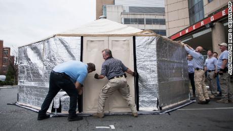 Members of the State Medical Assistance Team assemble a triage tent outside UNC Health&#39;s emergency department in Chapel Hill, North Carolina, to reduce pressure on the facility.