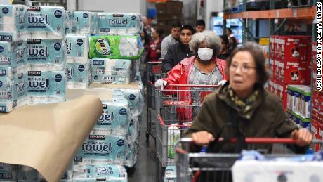 A line of shoppers wait to collect toilet paper at a Costco store in Novato, California on March 14, 2020. - Hoards of shoppers rushed to stock up on toilet paper, paper towels and cleaning supplies as communities begin hunkering down as a result of the Coronavirus. (Photo by Josh Edelson / AFP) (Photo by JOSH EDELSON/AFP via Getty Images)
