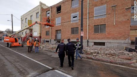 Police officers walk past rubble in Salt Lake City after Wednesday's earthquake.