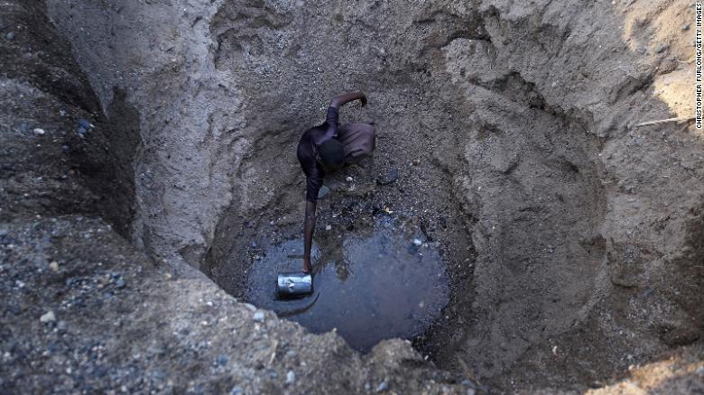Children from the remote Turkana tribe in Northern Kenya dig a hole in a river bed to retrieve water. 