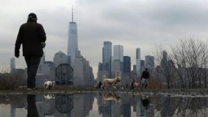 JERSEY CITY, NJ - MARCH 19: People walk their dogs in a park in front of the skyline of lower Manhattan in New York City on the first day of spring on March 19, 2020 in Jersey City, New Jersey. (Photo by Gary Hershorn/Corbis via Getty Images)