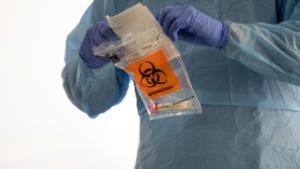 SEATTLE, WASHINGTON - MARCH 13: A nurse wearing protective clothing handles a potentially infected coronavirus swab at a drive-by testing center at the University of Washington Medical campus on March 13, 2020 in Seattle, Washington. UW Medical staff feeling potential symptoms of COVID-19 were asked to pass through a drive-through screening center for testing. (Photo by John Moore/Getty Images)