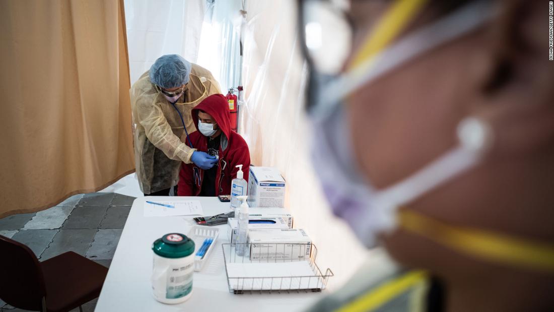 A doctor examines Juan Vasquez inside a testing tent at St. Barnabas Hospital in New York.