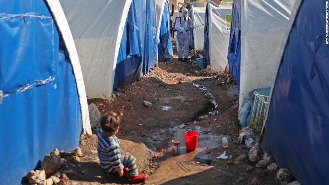 A member of the Syrian Violet relief group disinfects tents at a camp for displaced people in Kafr Jalis, Syria, on March 21, 2020.