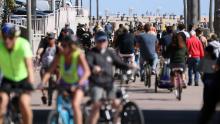 People ride their bikes on March 21, 2020, in Huntington Beach, California. 