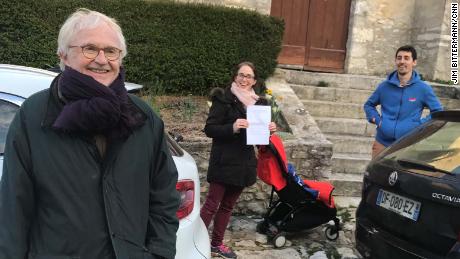 Neighbors Alain de Gourdon and his family out for a walk while social distancing. De Gourdon&#39;s daughter holds up the paperwork needed. 