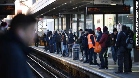 Passengers wait on the platform for a Central Line underground train in London.