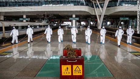 Staff members spray disinfectant at the Wuhan Railway Station on March 24.