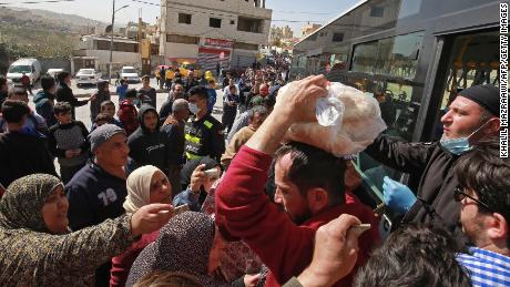 People queue to buy subsidised bread from a municipal bus in the Marka suburb of Amman on Tuesday.