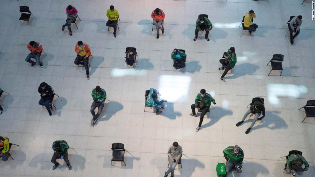 People practice social distancing as they wait for takeout food at a shopping mall in Bangkok, Thailand, on March 24, 2020.