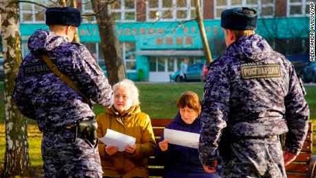 Russian Rosguardia (National Guard) soldiers speak to pensioners in Moscow, as the city ordered residents over 65 and those suffering from chronic conditions to stay home for 19 days.