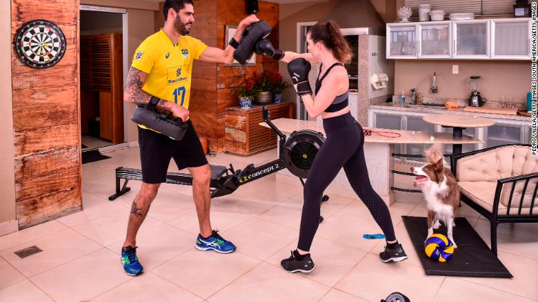 Evandro Guerra, player of the national Brazilian volleyball squad,  trains in his home with his wife.