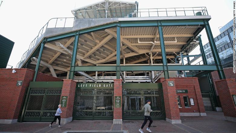 Joggers run past the entrance to Wrigley Field where the Chicago Cubs were scheduled to open its MLB season.