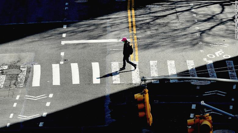 A person crosses the street on March 27, 2020 in New York City. - The US now has more COVID-19 infections than any other country, and a record number of newly unemployed people, as the coronavirus crisis deepens around the world. (Photo by Angela Weiss/AFP/Getty Images)