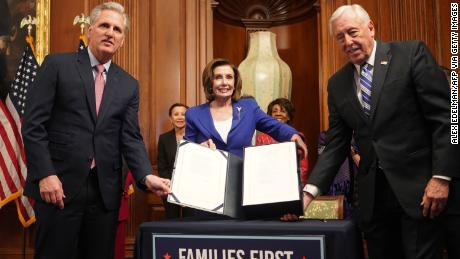 US Speaker of the House Nancy Pelosi (C) and Representatives Kevin McCarthy (L) and Steny Hoyer show the bill to the press after the House passed a $2 trillion stimulus bill, on March 27, 2020, at the US Capitol in Washington, DC - The House approved by a voice vote a $2.2 trillion rescue package, the largest economic stimulus package in American history, to aid a US economy and health care system battered by the coronavirus pandemic. (Photo by ALEX EDELMAN / AFP) (Photo by ALEX EDELMAN/AFP via Getty Images)