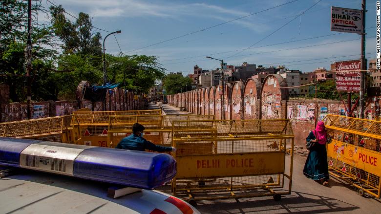 A health worker pulls a barrier aside to give way to an ambulance during the nationwide lockdown on March 25 in New Delhi.