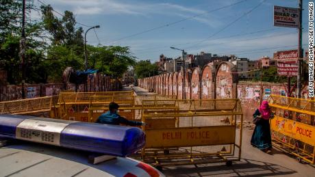 A health worker pulls a barrier aside to give way to an ambulance during the nationwide lockdown on March 25 in New Delhi.