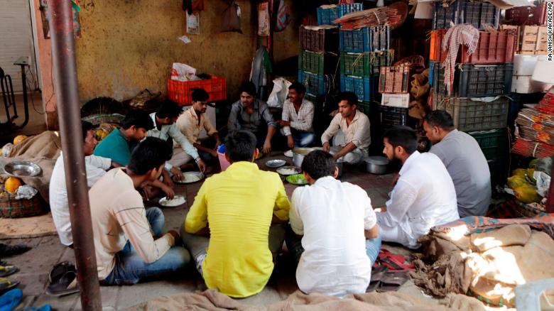 Vendors eat a meal at a wholesale market in Mumbai, India on March 24, one day before the nationwide lockdown.