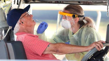 A Florida resident gets tested for the coronavirus with a nasal swab at a drive thru site at The Villages Polo Club, Monday, March 23, 2020. The testing site is operated by University of Florida Health with UF medical students performing the tests. 