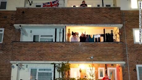 MANCHESTER,  - MARCH 26: People applaud the NHS from their balconies and gardens across the road from Wythenshawe Hospital on March 26, 2020 in Manchester, United Kingdom. The &quot;Clap For Our Carers&quot; campaign has been encouraging people across the U.K to take part in the nationwide round of applause from their windows, doors, balconies and gardens at 8pm to show their appreciation for the efforts of the NHS as they tackle the coronavirus (COVID-19). The coronavirus pandemic has spread to many countries across the world, claiming over 20,000 lives and infecting hundreds of thousands more. (Photo by Christopher Furlong/Getty Images)