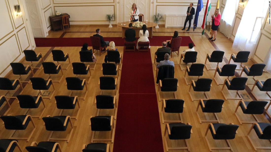 Gyorgy David Jablonovszky and his bride, Timea, are joined by close relatives during their wedding ceremony in Miskolc, Hungary, on March 28, 2020. Because of the coronavirus, engaged couples across the globe &lt;a href=&quot;https://www.cnn.com/2020/03/28/us/couples-livestreaming-weddings-wellness-trnd/index.html&quot; target=&quot;_blank&quot;&gt;have had to rethink their walks down the aisle.&lt;/a&gt;