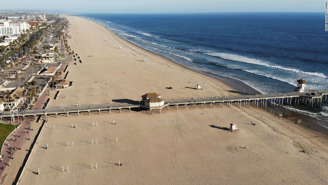 Huntington Beach, California, and its shuttered pier are empty on Saturday, March 28. The city closed its pier and parking lots along the beach to try to limit the spread of the coronavirus.