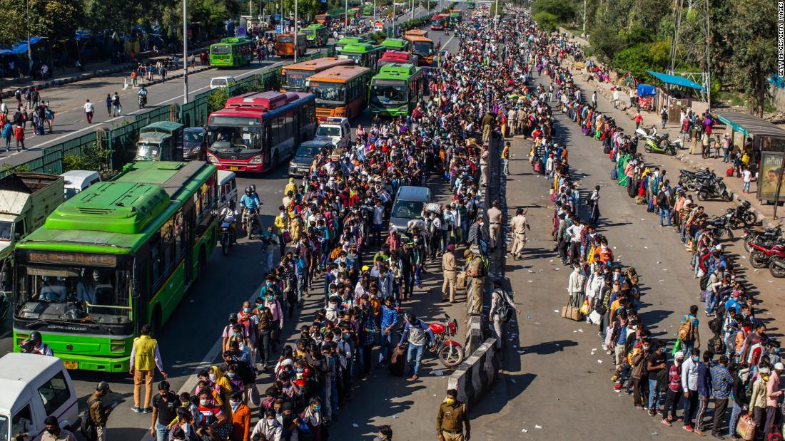 Crowds of migrant workers wait to board buses outside New Delhi.