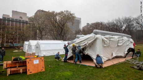 A Samaritan&#39;s Purse crew works on building an emergency field hospital equipped with a respiratory unit in New York&#39;s Central Park across from the Mount Sinai Hospital, Sunday, March 29, 2020.