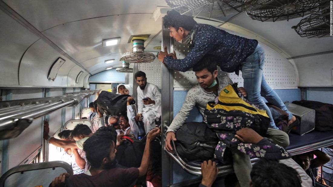 Migrant workers and their families board an overcrowded passenger train in Mumbai on March 21. Many workers had already left India's big cities before this weekend. 