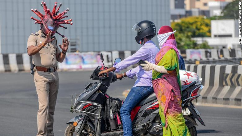 Police inspector Rajesh Babu in a coronavirus-themed helmet, talking to commuters in Chennai, India, on March 28.