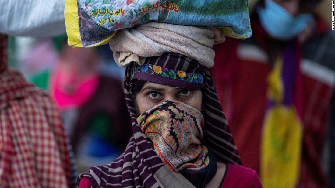 A migrant worker carries her belongings along a roadside in New Delhi.