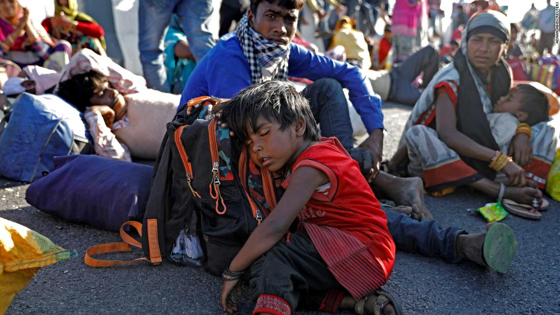 The child of a migrant worker sleeps alongside a highway after the family failed to catch a bus.