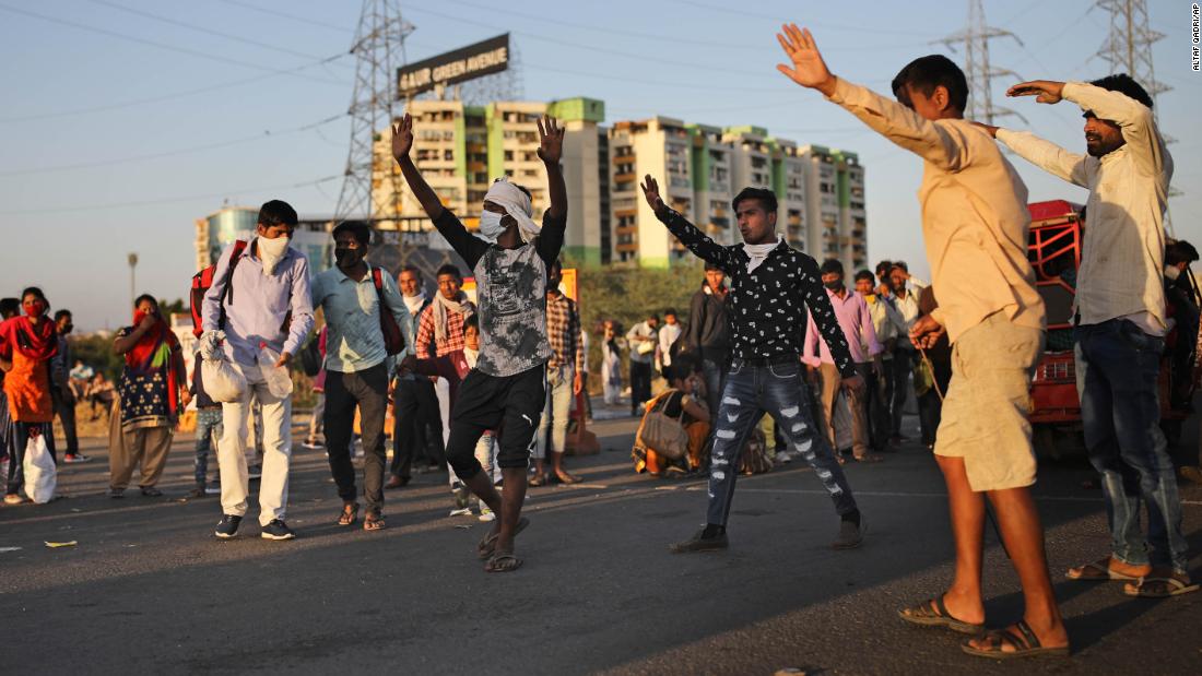 People try to hail a bus in New Delhi.