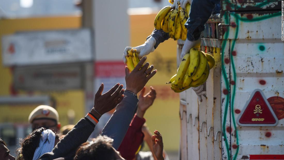 Workers collect food being handed out near the Anand Vihar Bus Terminus in New Delhi.