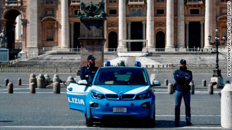 Italian police officers stand guard at a closed St. Peter&#39;s Square in the Vatican.