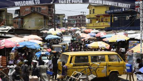 People walk in a crowded market in defiance to a social spacing order, to make last minute shopping ahead of a curfew, at the Mushin Market in Lagos. 