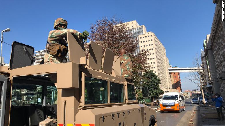 Two South African soldiers sit on top of their armored personnel carrier in Johannesburg city center.