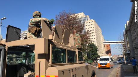 Two South African soldiers sit on top of their armored personnel carrier in Johannesburg city center.