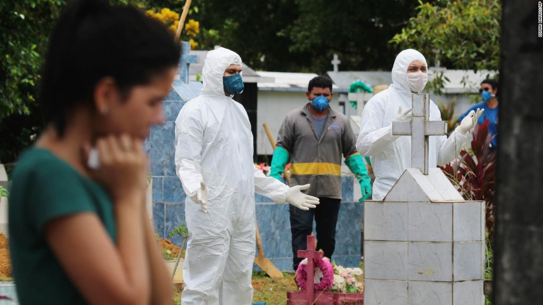 People pray next to the grave of musician Robson de Souza Lopes after his burial in Manaus, Brazil, on March 31, 2020. According to authorities at the Amazonas Health Secretary, the 43-year-old died after being diagnosed with the novel coronavirus.