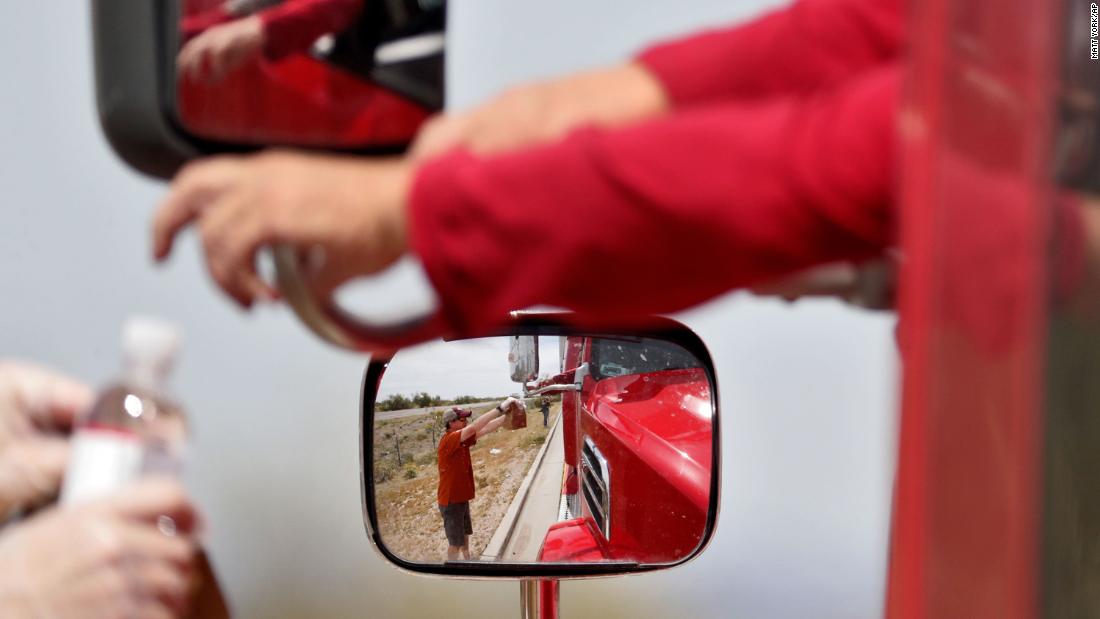 Chris Lyndberg hands out a free lunch to a truck driver at a rest area along Interstate 10 in Sacaton, Arizona, on March 31, 2020. The Arizona Trucking Association was giving away 500 Dilly&#39;s Deli lunches to show its appreciation for truck drivers who have been delivering medical supplies, food and other necessities during the coronavirus pandemic.