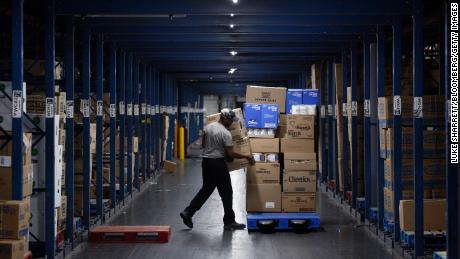 A worker loads boxes onto a pallet at a Kroger Co. grocery distribution center in Louisville, Kentucky, on March 20, 2020.