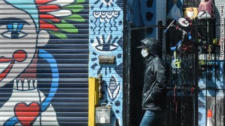 A person wears a protective masks while walking past street art in the Bushwick neighborhood of Brooklyn on April 2, 2020 in New York City.