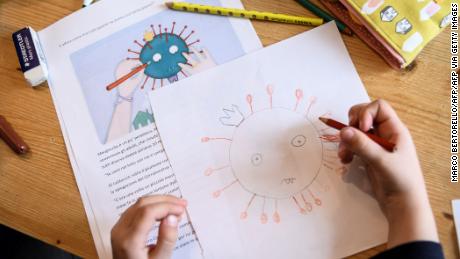 A child draws a COVID-19 coronavirus as part of school homeworks.